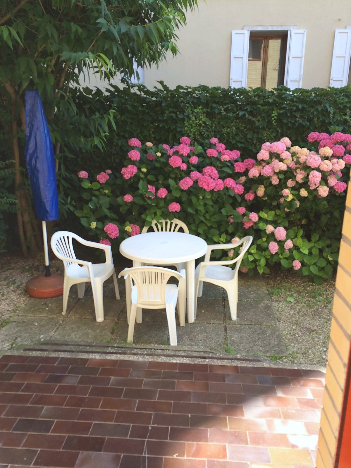Zona relax con tavolo bianco e ortensie rosa